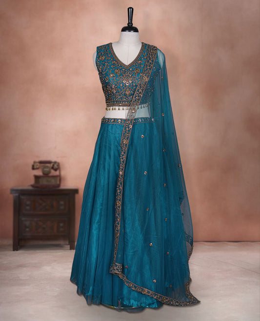 Dark blue colour lehenga set with stitched sleeveless Antique thread embroidered & beats worked  blouse featuring sheer neckline, matching stitched flared lehenga, and plain sheer dupatta.