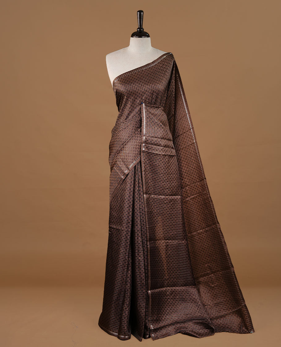 Brown colour Semi Tussar saree featuring an elegant zari fancy check pattern on the body, highlighted with a small border for a refined look. Comes without a blouse piece.