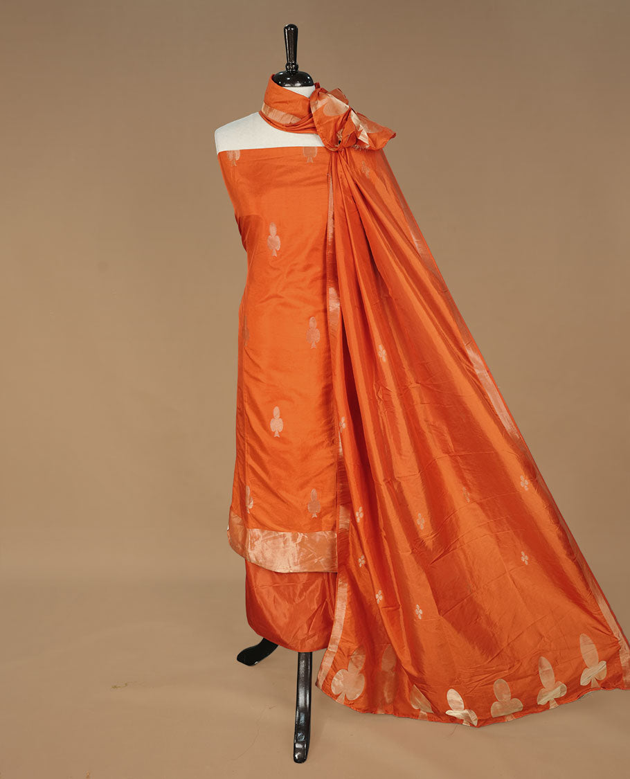 Orange colour churidhar material featuring gold zari card motifs on body, paired with matching bottom and Dupatta.