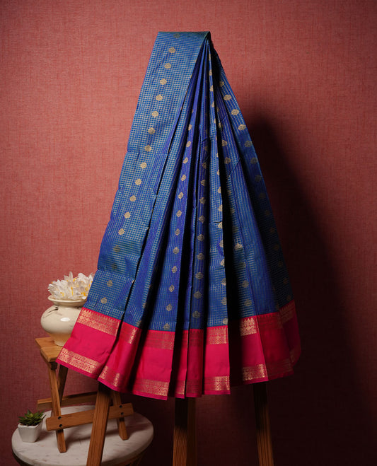 Blue colour semi silk saree highlighting gold zari check pattern  and motifs across body, featuring contrast pink colour border with gold zari pattern, comes with matching blouse .