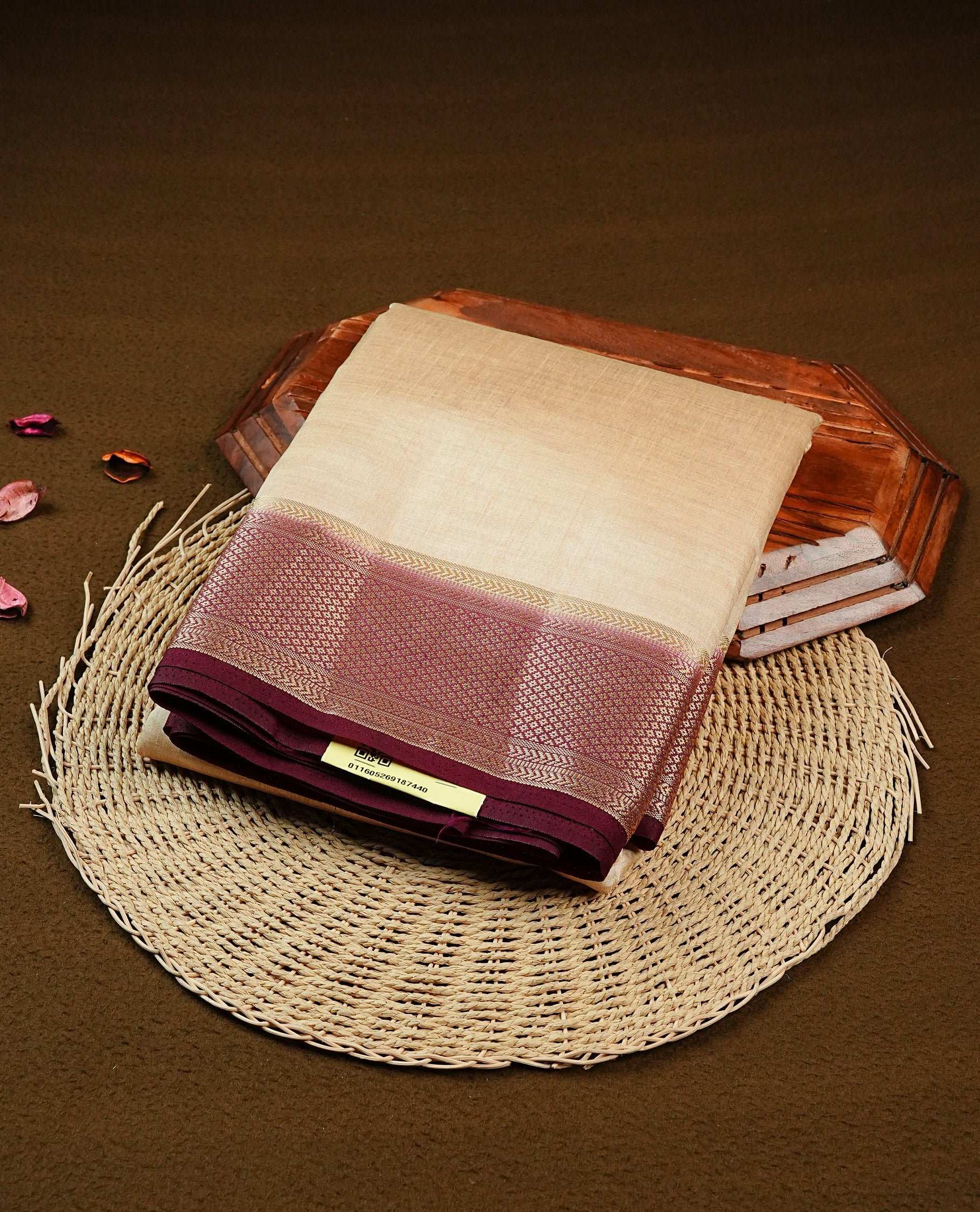 Cream colour Semi Tussar silk saree featuring an elegant plain body, accentuated by a contrast Chocolate border adorned with intricate gold zari work, paired with a matching blouse piece.