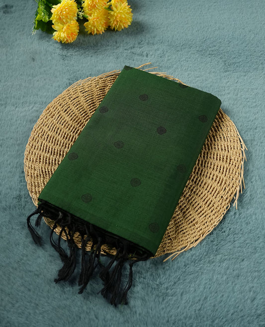 Dark green colour poly cotton saree with black abstract butti motifs on the body, paired with a matching pallu with dense black textured round butta pattern, and a coordinated all‑over textured round butta printed blouse piece.