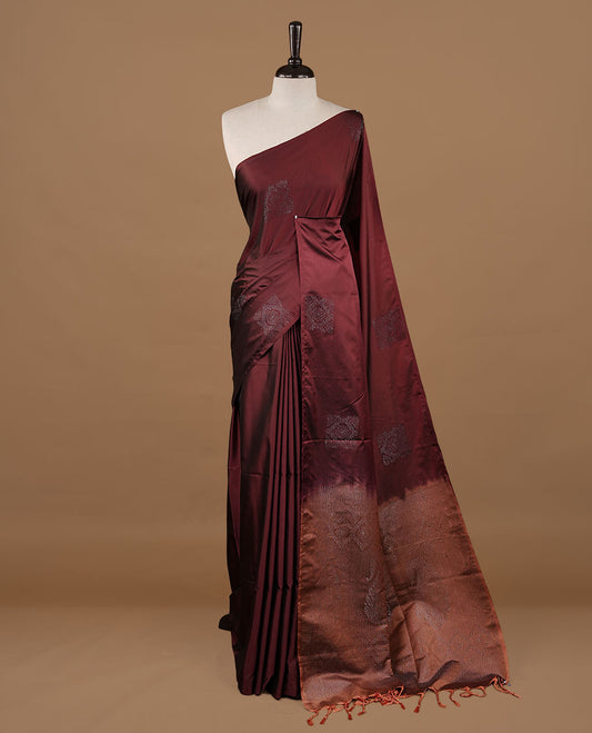 Maroon colour soft silk saree features a sleek borderless design with intricate antique zari motifs, flowing into a striking contrast biscuit orange pallu and a matching blouse piece.