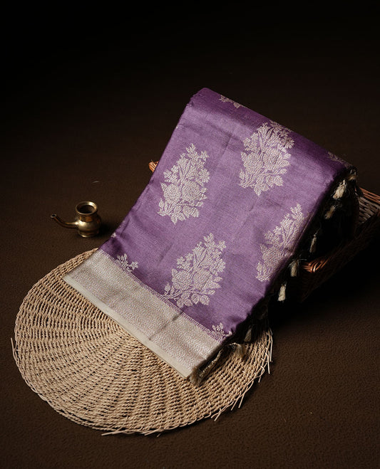 Purple colour pure banaras tusser silk saree highlighting antique zari pattern across body, with contrast cream colour with zari border and paired with matching blouse