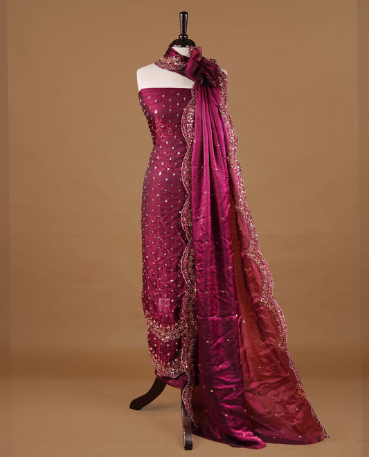 Burgundy colour churidhar material featuring cut beads and sequins work on the body, paired with a matching unstitched bottom and worked dupatta.
