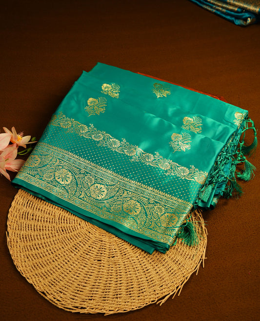 Green colour Banaras Satin Crepe saree featuring gold zari floral motifs on the body, a richly woven traditional border with intricate gold zari detailing, and paired with a matching blouse.