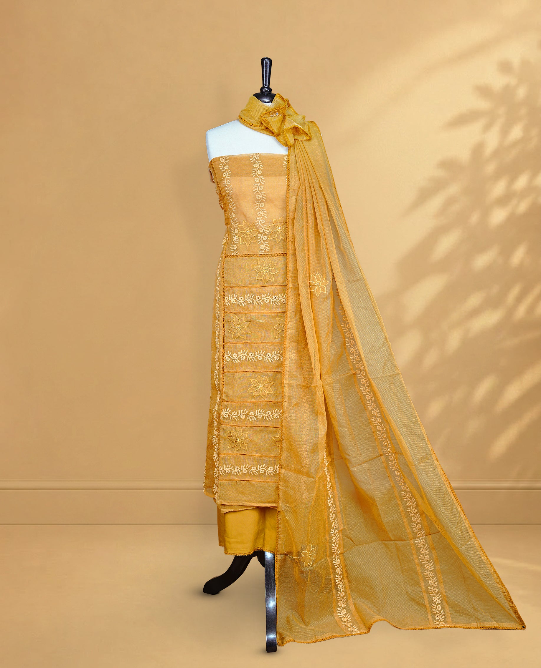 Mustard colour Salwar material featuring Self colour Floral Thread pattern, Matching bottom and paired with Same colour with thread patterned Dupatta.