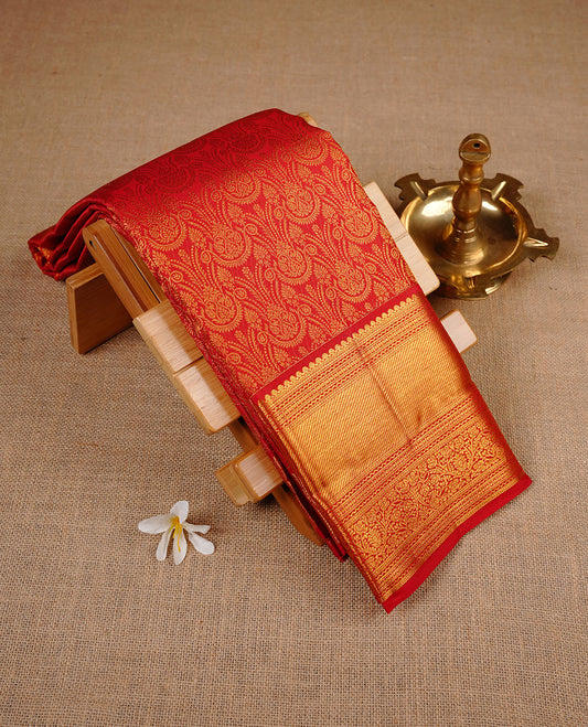 Red colour kancheepuram silk saree featuring gold zari pattern across body, complemented by selfcolour border traditional zari border, paired with matching blouse piece.