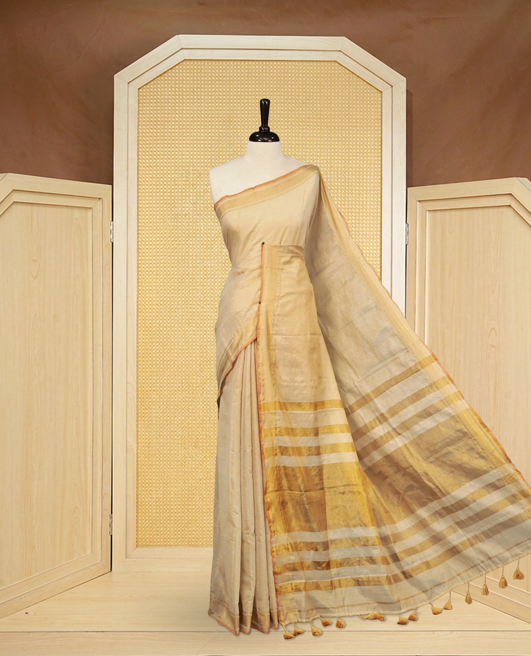 Light Gold colour Semi Tissue Silk saree featuring Elegant plain body, Enhanced with Gold tissue Border & Striped Pallu & beautiful Tassels for Elegant Prefect Look.