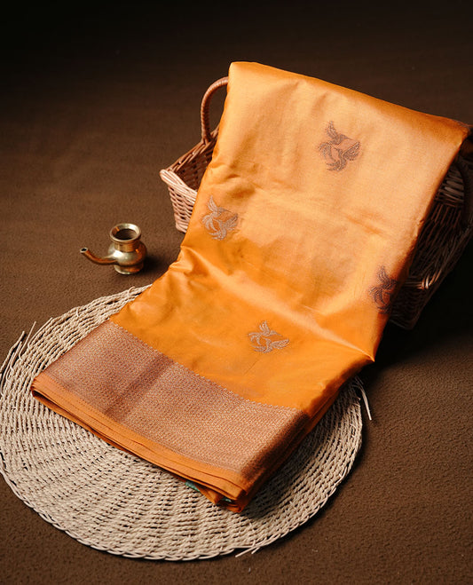 Mustard colour semi banaras tussar silk saree highlighting gold zari bird motifs on body, complemented by self colour with antique zari border, paired with matching blouse piece.