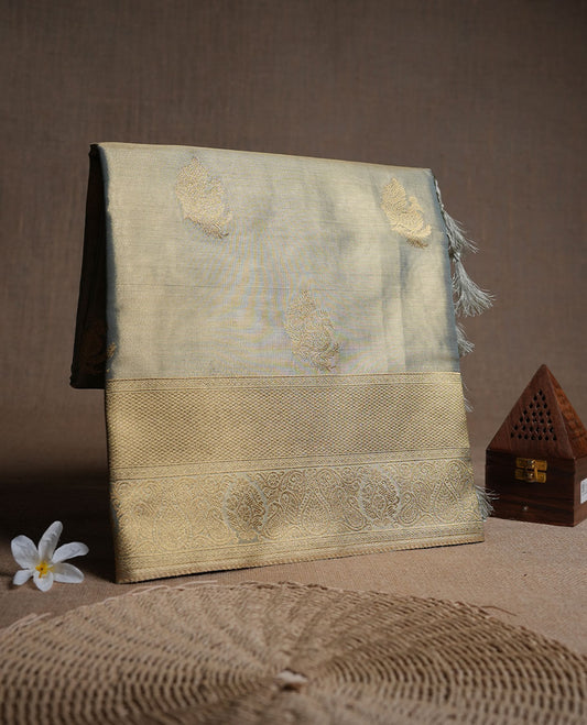 Dual tone teal and gold colour tissue brocade saree featuring antique gold zari motifs on the body with a rich traditional zari border and pallu, paired with a matching blouse piece.