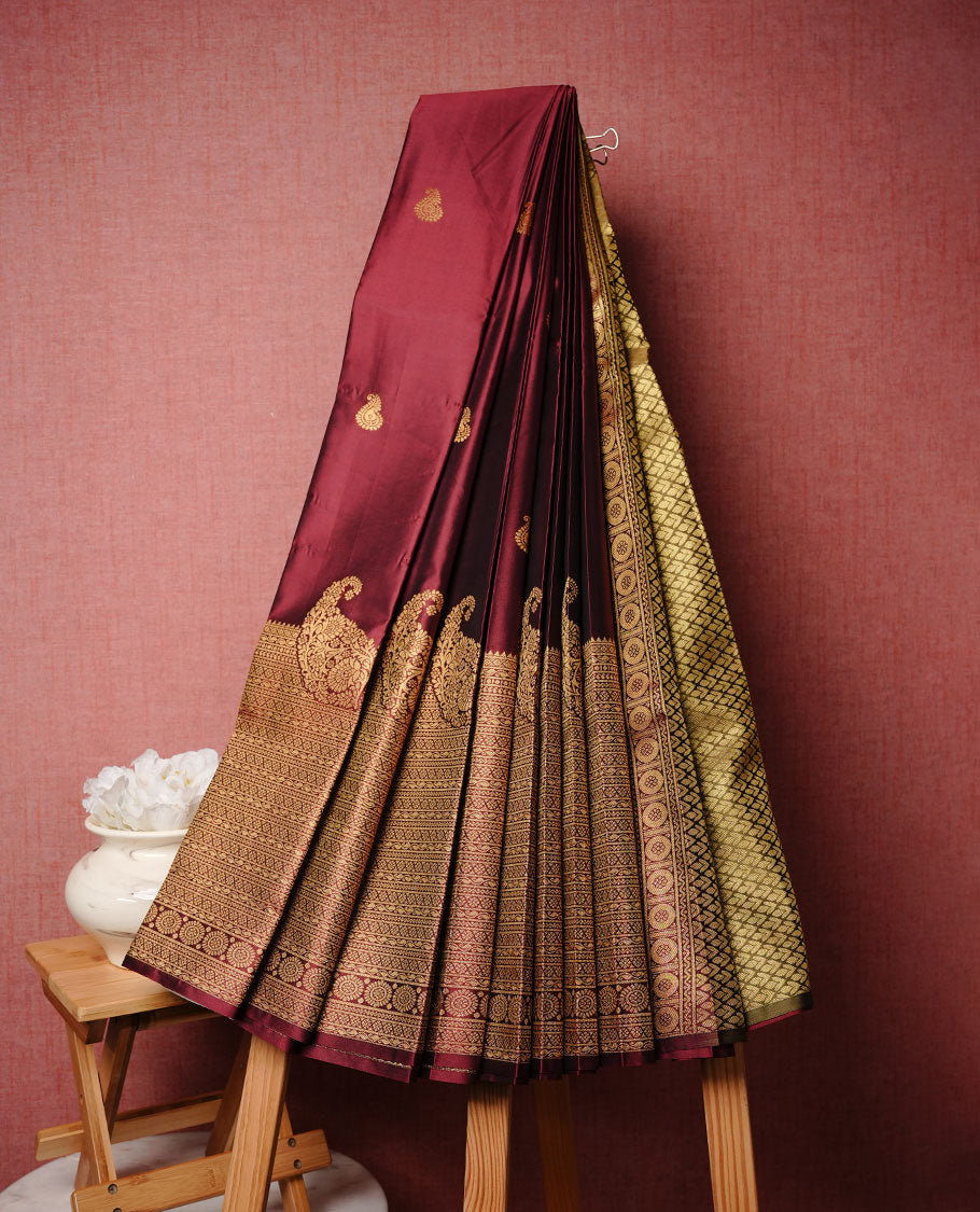 Maroon colour soft silk saree featuring motifs on body, complemented by self colour with traditional border, paired with contrast colour blouse piece.