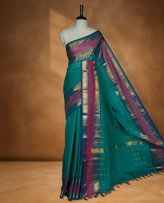 Green colour chettinad cotton saree featuring Elegant plain body highlighting contrast magenta and blue colour with gold zari traditional border, pallu and paired with matching blouse piece.