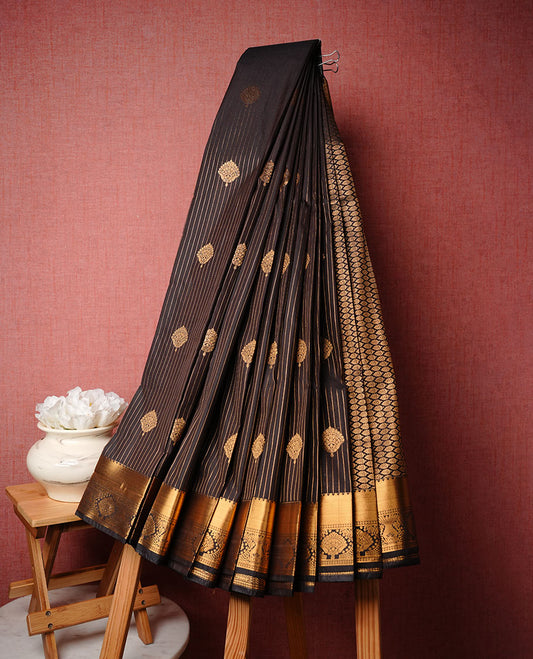 Dark chocolate colour soft silk saree featuring Gold zari stripes & motifs on body, complemented by self colour with traditional border, paired with matching blouse piece.