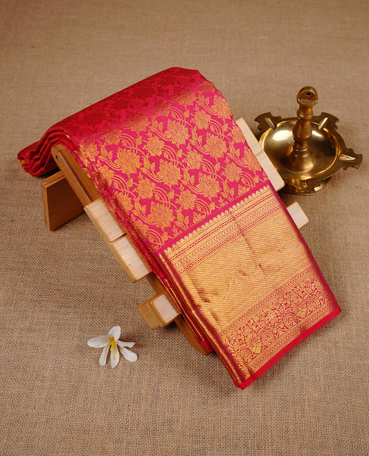 Rasberry colour kancheepuram silk saree featuring gold zari pattern across body, complemented by selfcolour border traditional zari border, paired with matching blouse piece.