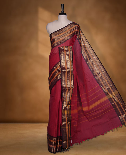 Red colour chettinad cotton saree featuring plain body, contrast chocolate brown and mustard colour with traditional gold zari border paired with matching blouse.