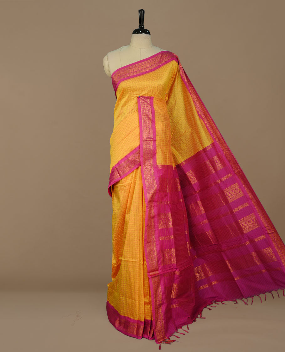 Yellow colour kalyani cotton saree featuring gold zari check pattern on body, complemented by Magenta colour with Antique zari border, paired with matching blouse piece.