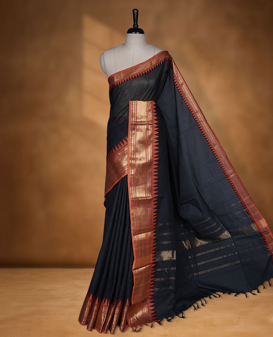 Black colour chettinad cotton saree featuring Elegant plain body highlighting contrast orange colour colour with gold zari traditional border, pallu and paired with matching blouse piece.