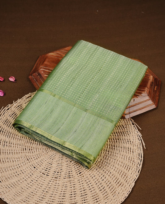 Light jade colour semi tussar silk saree featuring elegant gold zari dotted stripes across the body, enhanced with a rich zari woven border. Comes with a matching blouse piece.
