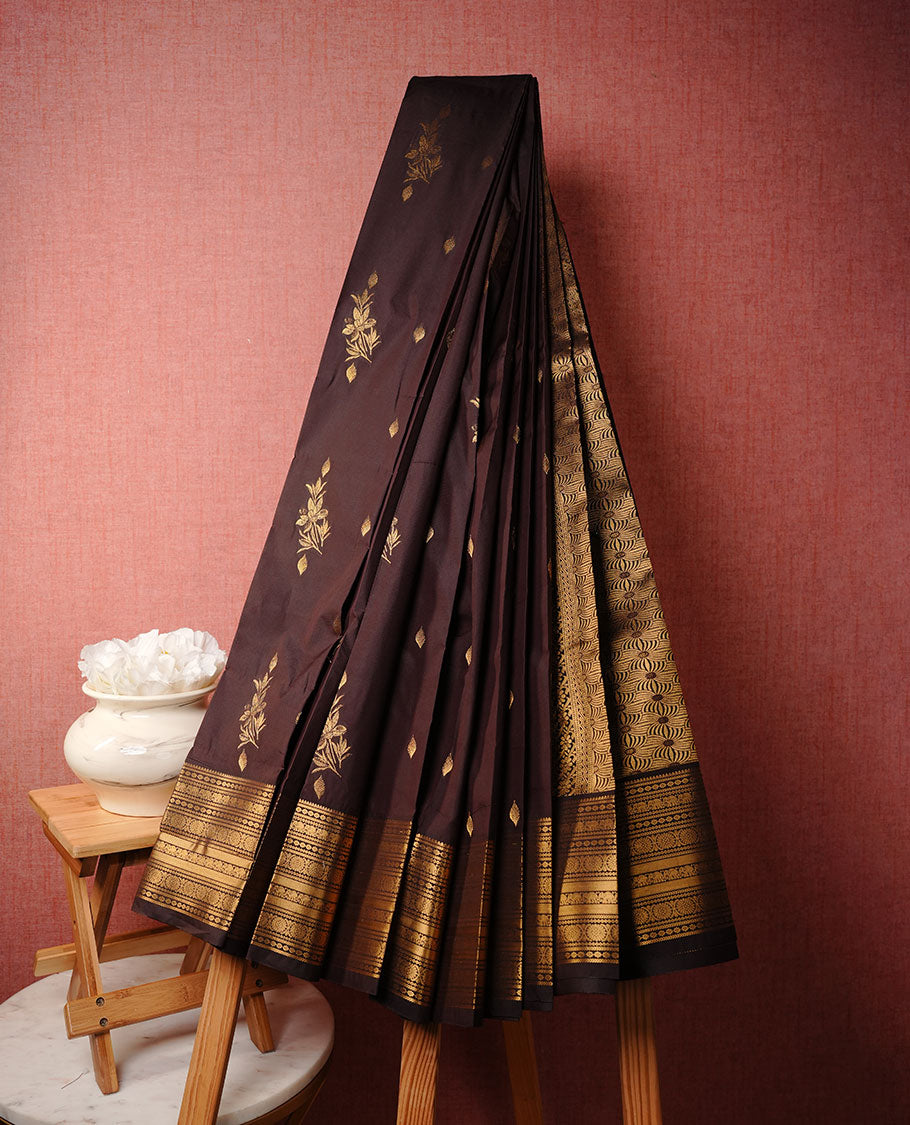 Chocolate colour soft silk saree featuring Gold zari motifs on body, complemented by self colour with traditional border, paired with matching blouse piece.