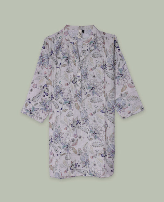 White tunic top with pastel floral and paisley print, band collar, pintuck-detailed front with half button placket, and three-quarter sleeves.