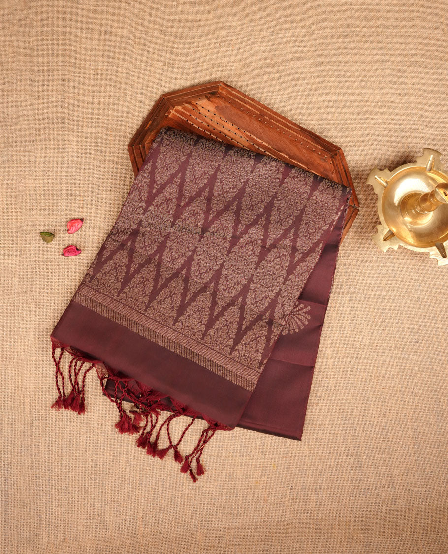 Brown colour soft silk saree featuring gold zari motifs on body, complemented by self colour with traditional border with tassel at pallu, paired with matching blouse piece.