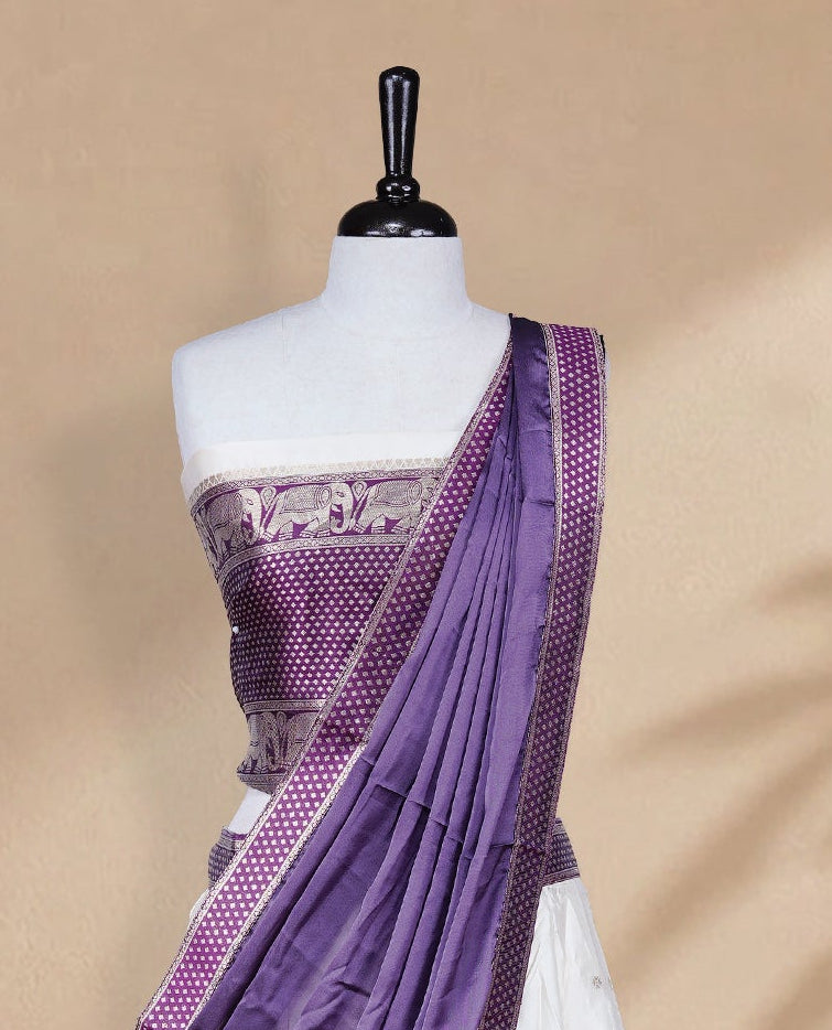 Cream colour Half saree featuring Gold zari buttas on skirt with Zari border on contrast Purple colour border, Unstitched Blouse and matching dupatta.