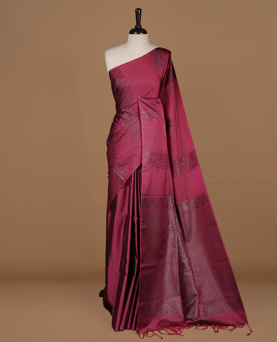 Dusty magenta soft silk saree features a sleek borderless design with intricate antique zari motifs, flowing into a seamless self colored pallu and a matching blouse piece.