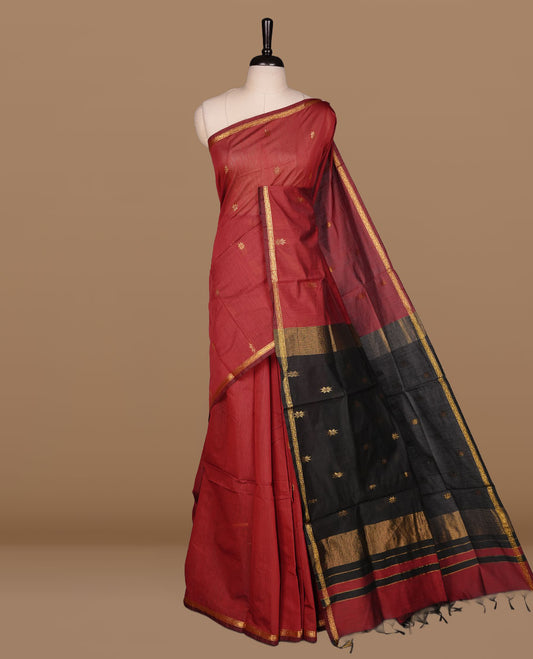 Maroon colour Maheshwari cotton saree features elegant gold zari motifs across the body, a classic gold zari border, a striking contrast pallu, and a matching blouse piece.