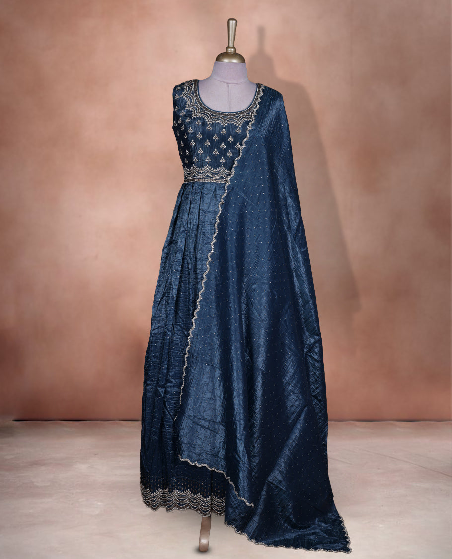 Midnight blue colour stitched gown set with sleeveless embroidered yoke, flared ankle‑length silhouette, and attached dupatta featuring dainty butti work and scalloped beaded edging.