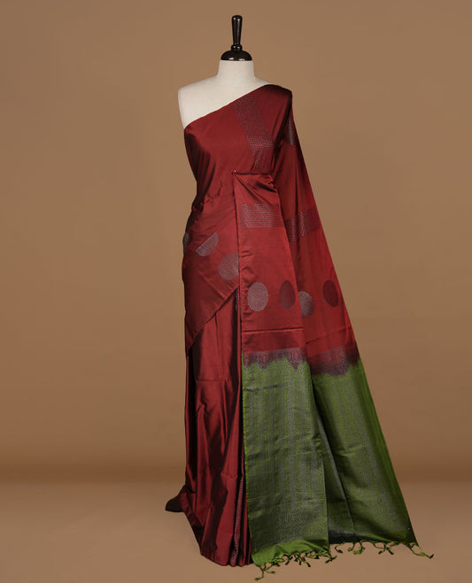 Brown colour soft silk saree features a sleek borderless design with intricate antique zari motifs, flowing into a striking contrast green pallu and a matching blouse piece.