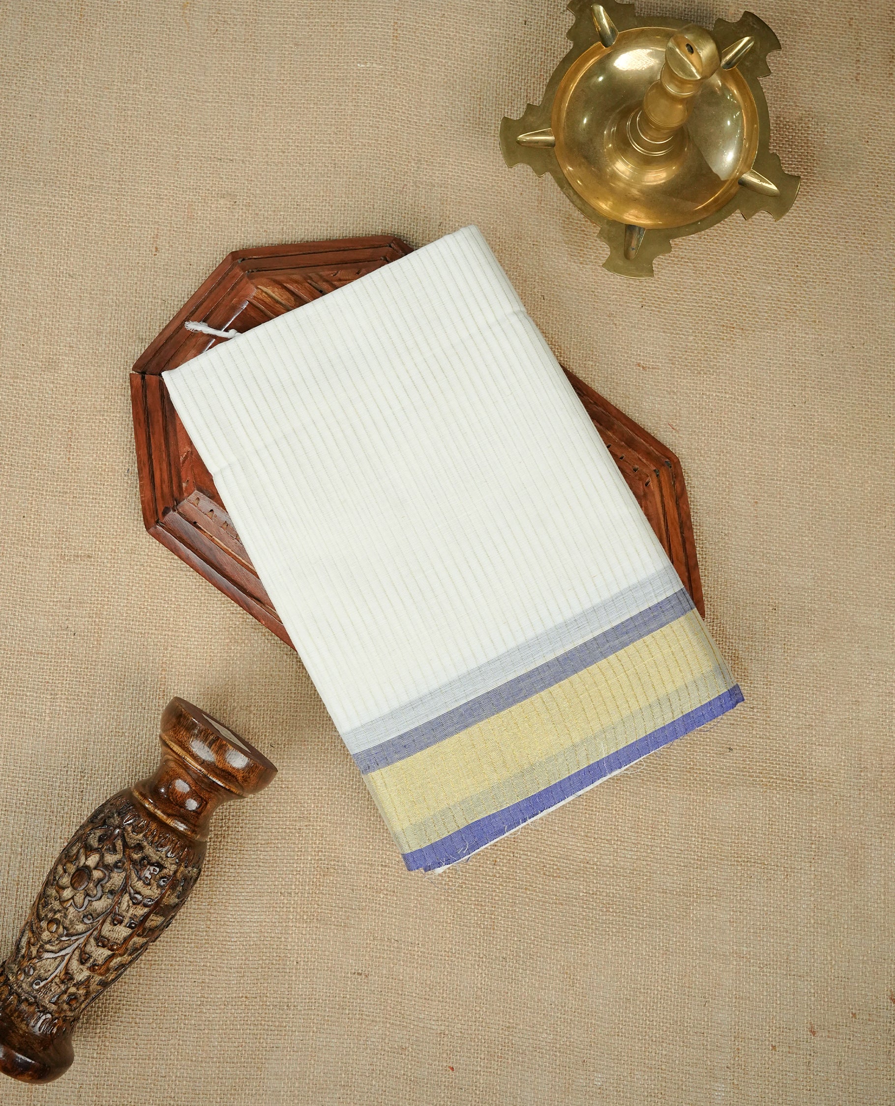White colour chettinad cotton saree Featuring Gold zari strips on body, complemented by contrast Blue colour with zari border, comes with matching blouse piece.