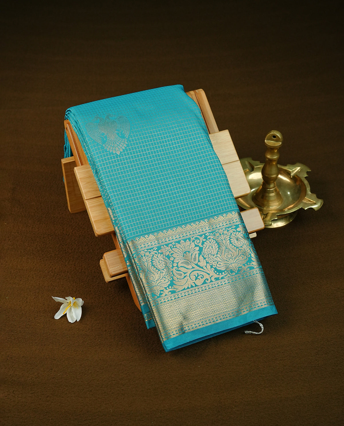 Sky blue colour semi wedding saree featuring gold zari check with motifs on body complemented by Self colour with traditional border, comes with matching blouse piece.