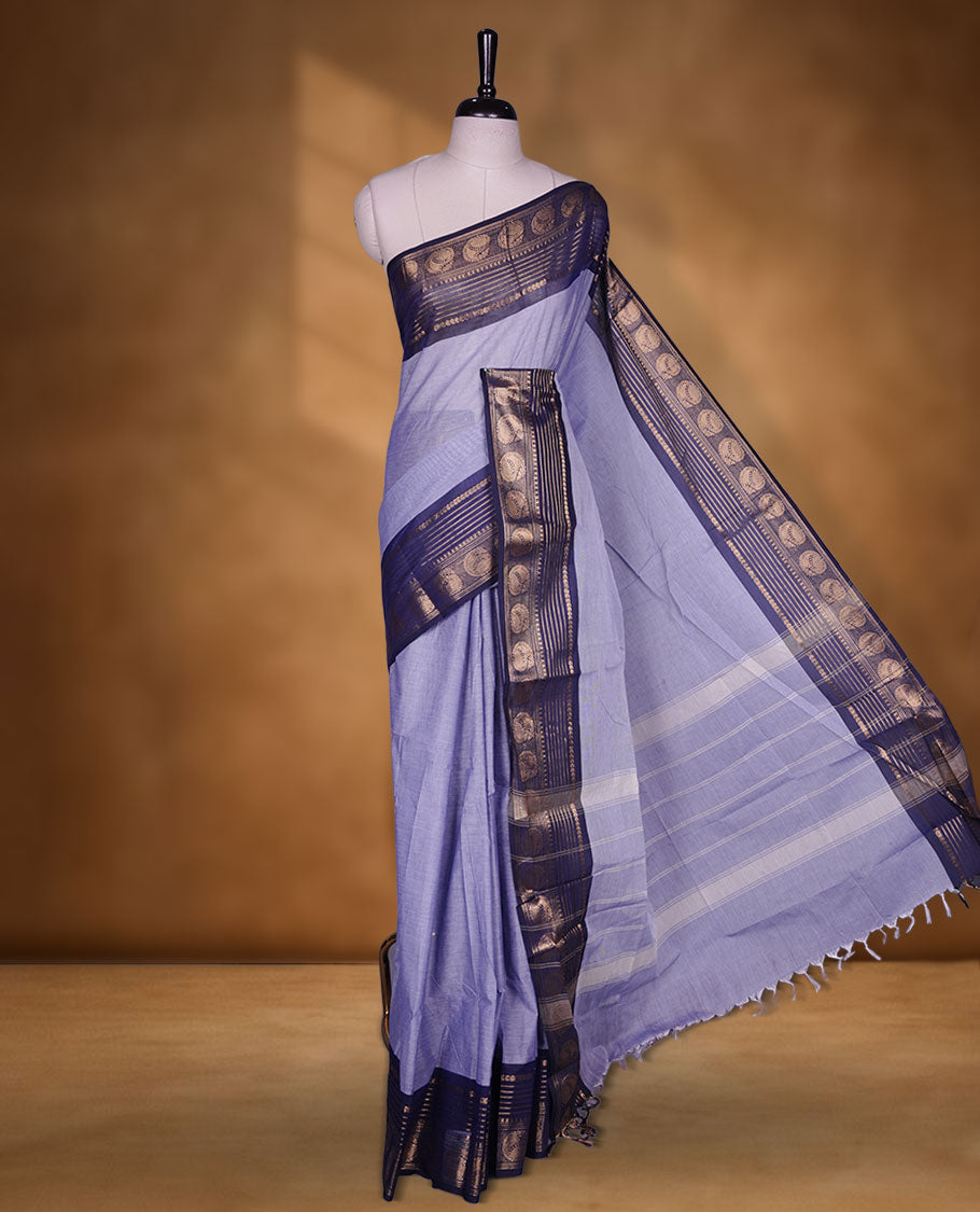 Lavender colour chettinad cotton saree featuring plain body, contrast Dark blue colour with traditional gold zari border paired with matching blouse.