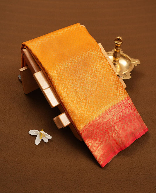 Orange colour semi silk brocade saree featuring intricate Gold Floral Square kodi patterns across the body, complemented by a contrast red colour woven border and pallu, paired with a matching blouse.
