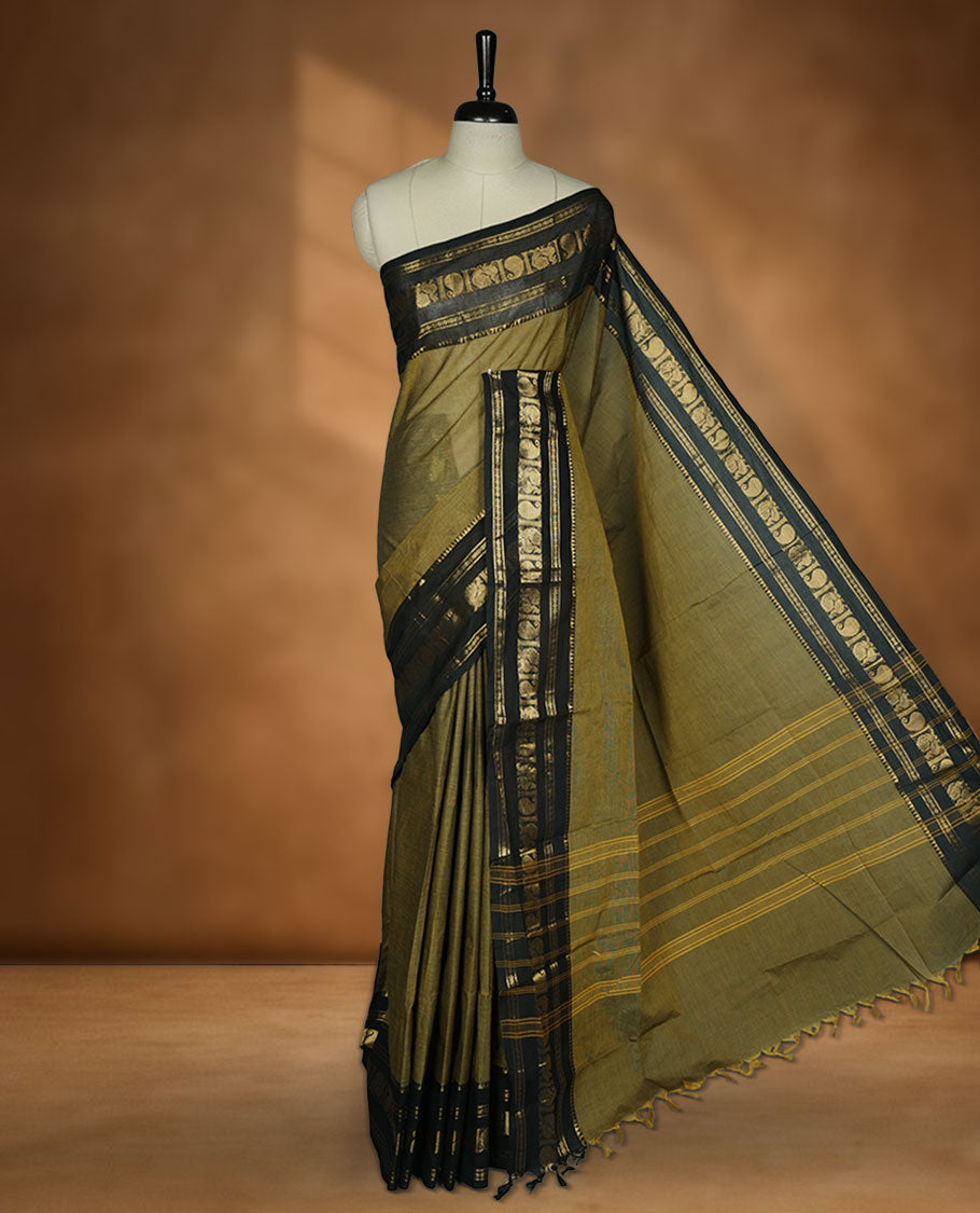 Olive Drab colour chettinad cotton saree featuring plain body, paired with a black colour traditional gold zari border paired with matching blouse.