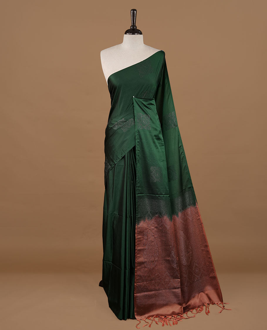 Green colour soft silk saree features a sleek borderless design with intricate antique zari motifs, flowing into a striking contrast Biscuit orange pallu and a matching blouse piece.