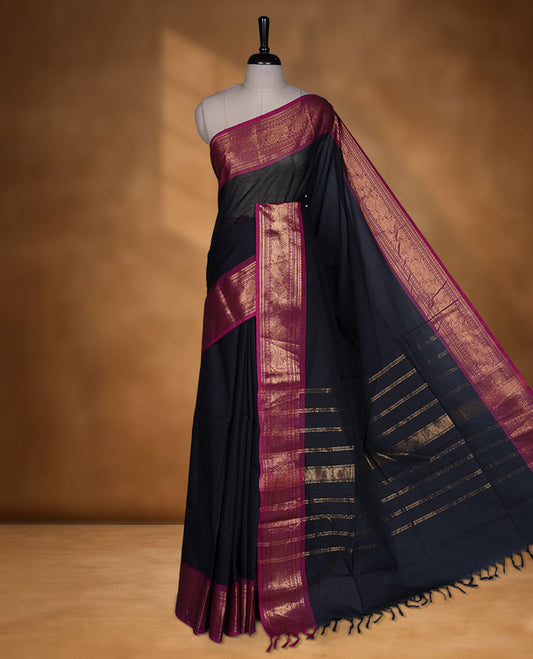 Black colour chettinad cotton saree featuring elegant plain body highlighting contrast magenta colour with gold zari traditional border, pallu and paired with matching blouse piece.