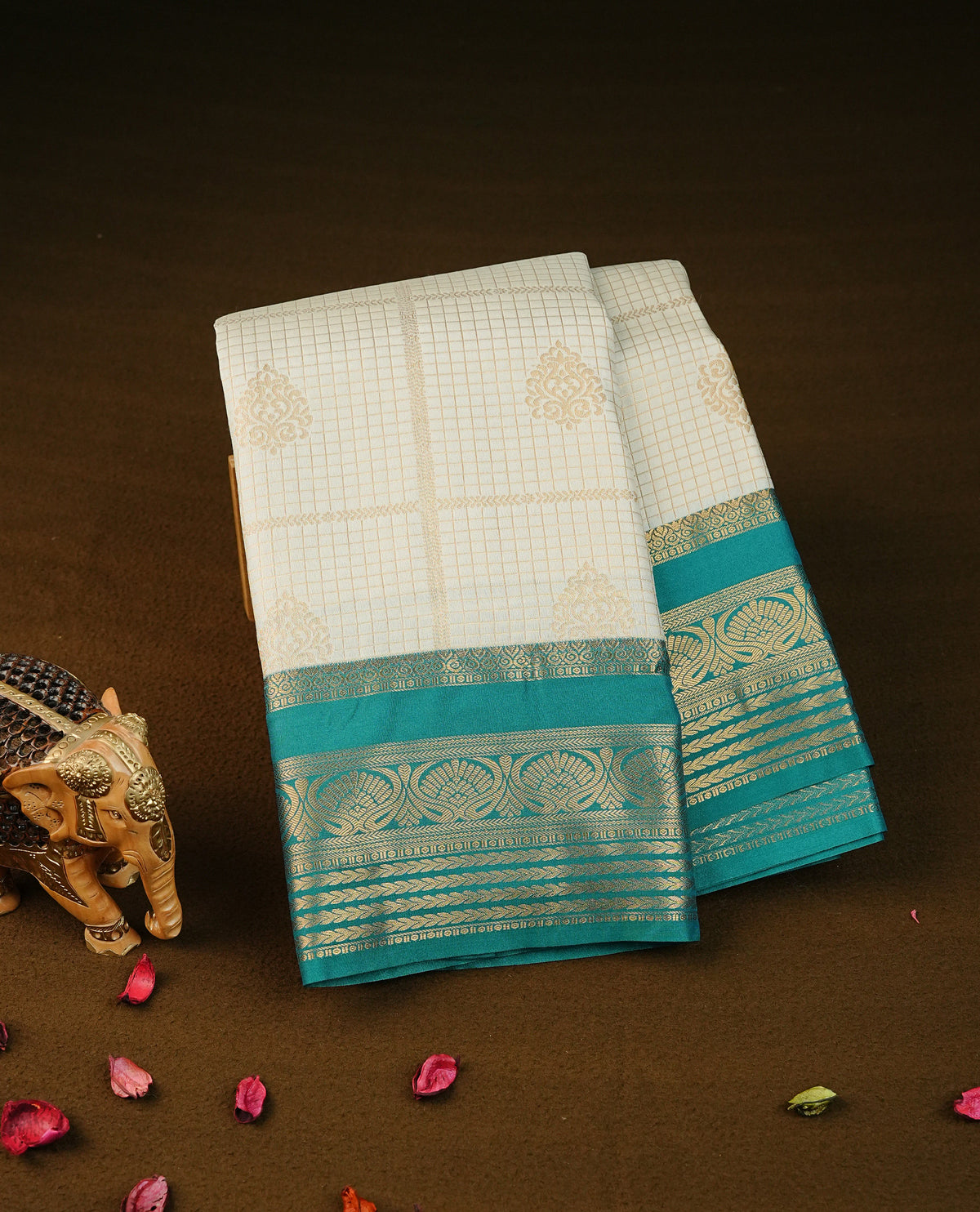 Cream colour semi wedding silk saree featuring gold zari checks with motifs on body,contrast teal green colour with traditional border on body, rich pallu comes with matching blouse piece