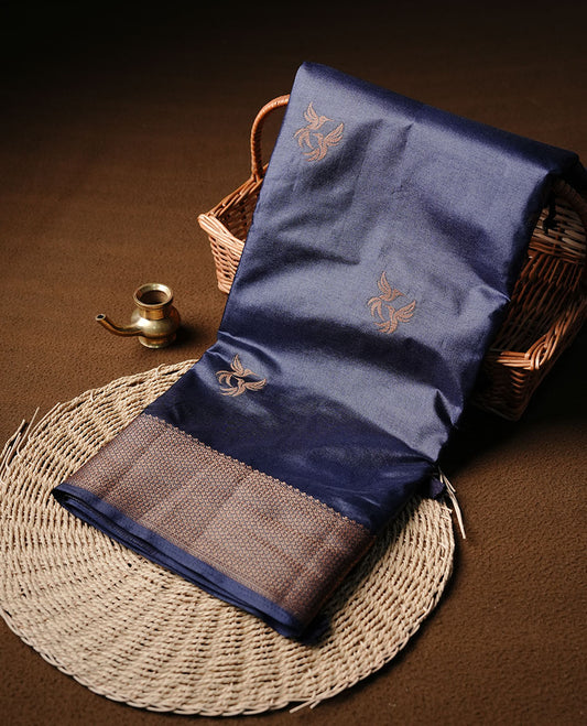 Navy blue colour semi banaras tussar silk saree highlighting gold zari bird motifs on body, complemented by self colour with antique zari border, paired with matching blouse piece.