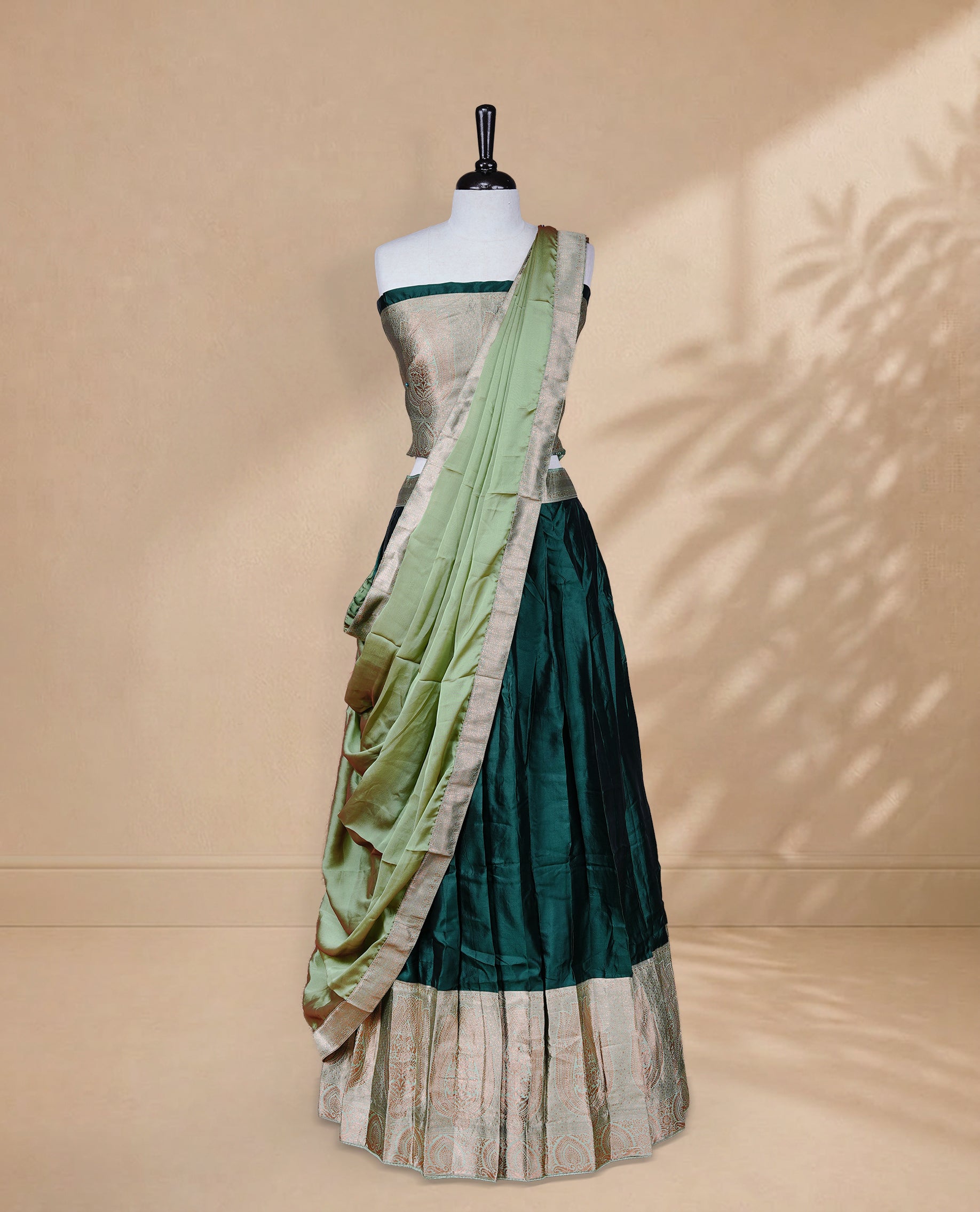 Green colour Half saree featuring Plain skirt with Zari border on contrast Light green colour border, Unstitched Blouse and matching dupatta.