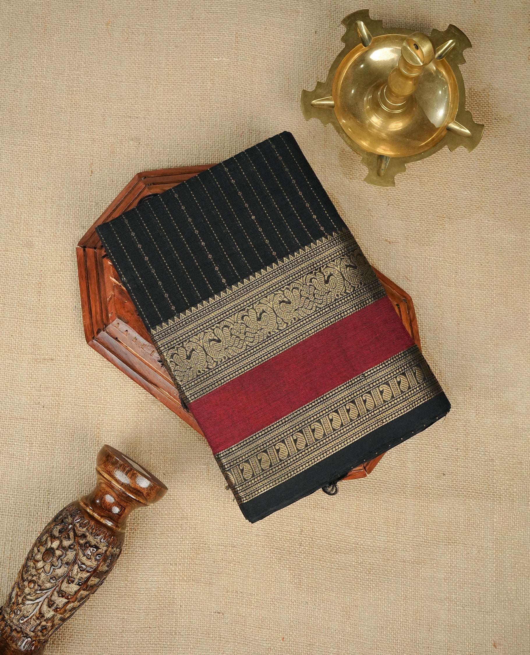 Black colour chettinad cotton saree Featuring Gold zari Strips on body, complemented by contrast Maroon colour with zari border, comes with matching blouse piece.