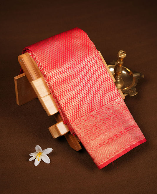 Red colour semi soft silk brocade saree featuring elegant self-woven floral motifs across the body, highlighted with a richly detailed self-colour border and pallu, paired with a matching blouse.