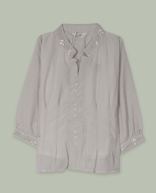 Cream three-quarter sleeve shirt top with embellished band collar and cuffs, front button placket, and soft pleating below the placket.