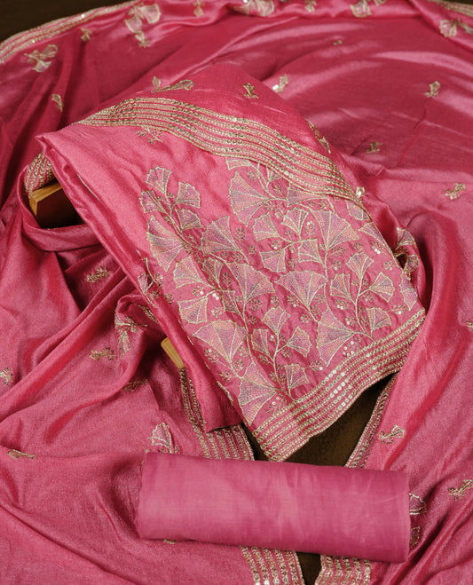 Pink colour churidar material with subtle mirror and thread embroidery, finished with delicate border detailing and paired with a matching plain bottom and dupatta.