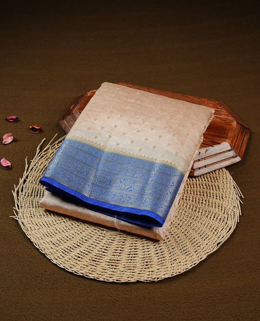 Light Gold Tussar saree featuring Gold zari buttas on body, complemented by contrast Blue Colour with Gold zari border, comes with matching blouse piece.