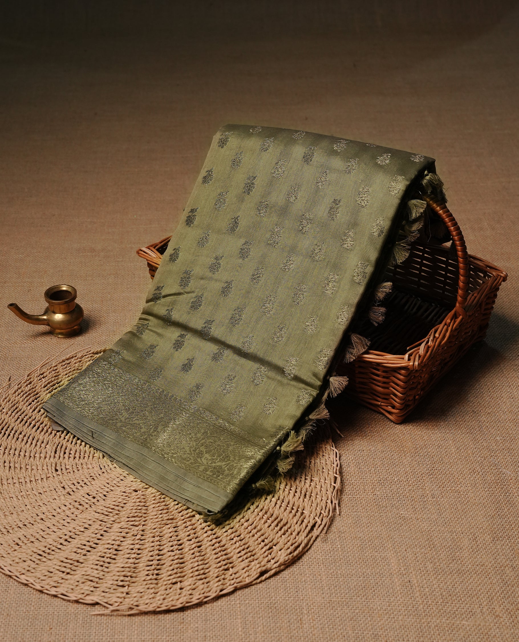 Olive colour semi tussar silk saree featuring elegant Antique zari motifs across the body, designed with a subtle borderless zari finish for a sophisticated traditional look. Paired with a matching blouse piece.