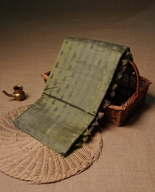 Olive colour semi tussar silk saree featuring elegant Antique zari motifs across the body, designed with a subtle borderless zari finish for a sophisticated traditional look. Paired with a matching blouse piece.