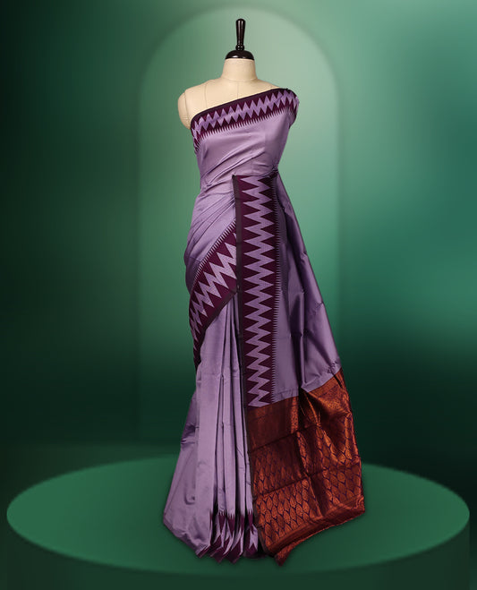 Lavender colour saree accentuated with bold deep purple zigzag woven borders and a contrasting rich copper zari pallu, paired with a matching blouse
