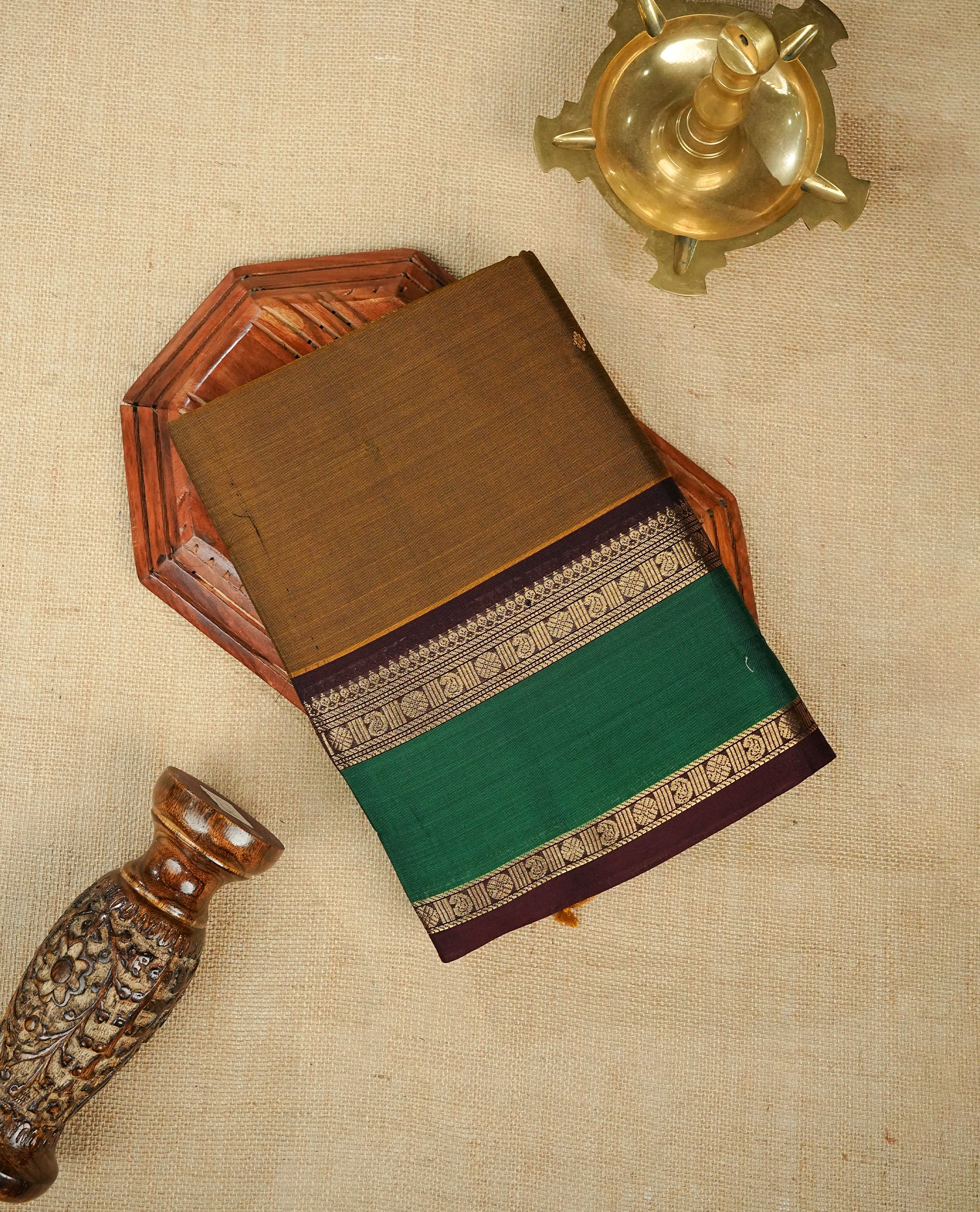Olive colour chettinad cotton saree featuring Elegant plain body, complemented by contrast Chocolate & green colour with gold zari border, comes with matching blouse piece.
